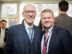 Two men in suits and ties smiling together for the camera