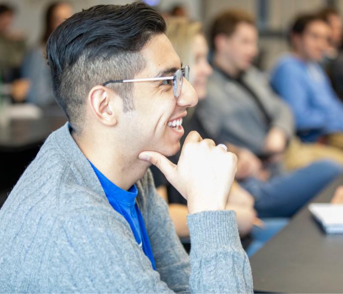 A student is seen smiling in a classroom.
