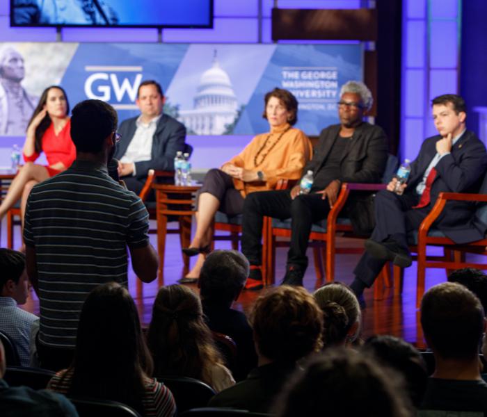 Panel of speakers talking to an audience